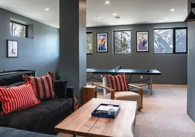 a living room with couches and a ping pong table at Ghost Peak Chalet - Ski-In Access in Port Mann
