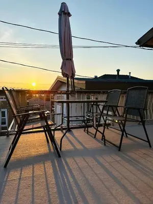 a table with an umbrella and two chairs on a roof at 4BR 2BA Downtown-View Cozy House with Parking, Pet-Free in Vancouver