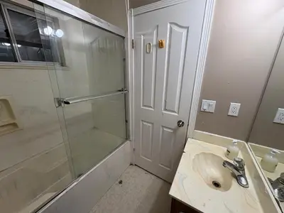 a bathroom with a glass shower and a sink at Delta Guest House - Scott Rd & Rapid Transit - Airport 20 Min - Free Parking & Fast Wi-Fi in Delta