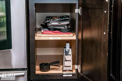 a wooden cabinet with a pile of clothes in it at 5BD Jungle Oasis - HotTub - BBQ - King Bed - Games - Garage in Edmonton
