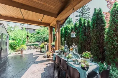 a patio with a table and chairs with plants at Grace Guest House in White Rock