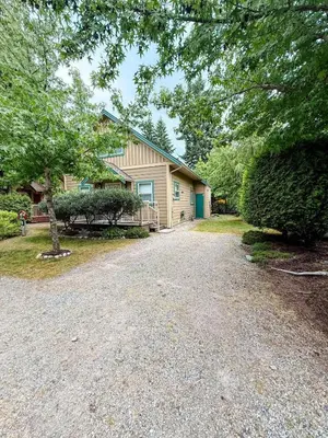a house with a gravel driveway in front of it at Oceanside Resort 3 BED 2 BATH with Indoor Pool and Hot Tub in Parksville