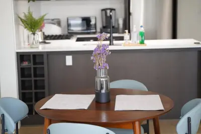 a table with a vase with purple flowers on it at Cozy Richmond Center Downtown 2B & 2B Apartment in Richmond