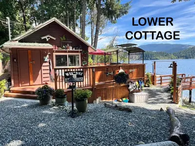 a tiny house on the shore of a lake at Mile 77 Cottages in Youbou