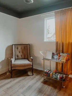 a room with a chair and a table and a window at Wilder Lodge in Fairmont Hot Springs