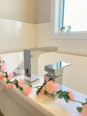 a glass table with flowers on it in a bathroom at The Downtown Oasis - A Spacious Family Friendly 3 Bedroom House Close to Everything in Edmonton