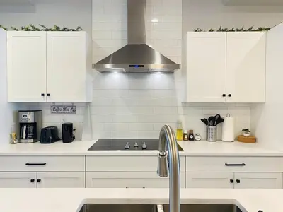 a kitchen with white cabinets and a sink at The Downtown Oasis - A Spacious Family Friendly 3 Bedroom House Close to Everything in Edmonton