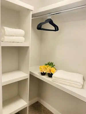 a walk in closet with towels and flowers on shelves at The Private Central Edmonton Suite - Comfortable & Fully-Equipped Basement Suite in Edmonton