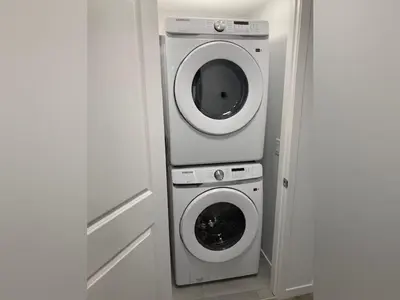 a washing machine and a washer in a room at Cozy 2 Bedroom Apartment in Calgary