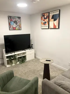 a living room with a tv and a couch and a table at Cozy 2 Bedroom Apartment in Calgary
