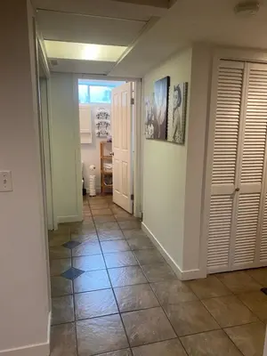 a hallway with a tile floor and white walls at Your Home Away From Home in Abbotsford