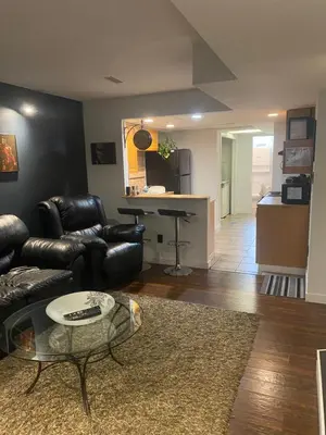 a living room with a leather couch and a table at Your Home Away From Home in Abbotsford