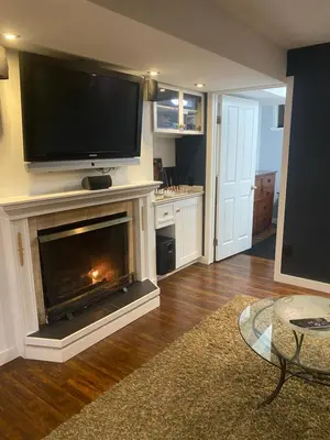 a living room with a fireplace with a flat screen tv at Your Home Away From Home in Abbotsford