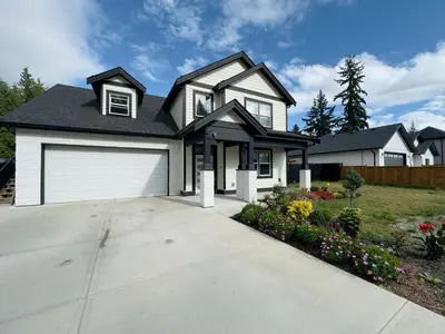 a house with a white garage at One-Bedroom Suite in Gibsons in Gibsons