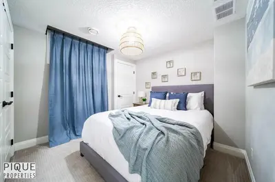 a bedroom with a large bed with blue curtains at Chic Retreat with Hot Tub - King Bed - Fireplace - WEM in Edmonton