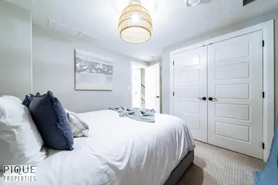 a bedroom with a white bed and a chandelier at Chic Retreat with Hot Tub - King Bed - Fireplace - WEM in Edmonton