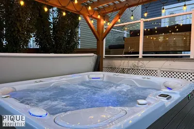 a jacuzzi tub sitting on top of a patio at Chic Retreat with Hot Tub - King Bed - Fireplace - WEM in Edmonton