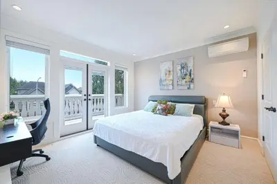 a bedroom with a bed and a desk and windows at #3 Room in Richmond