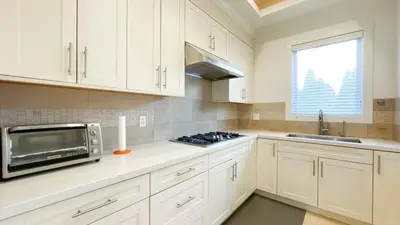 a kitchen with white cabinets and a microwave at #3 Room in Richmond