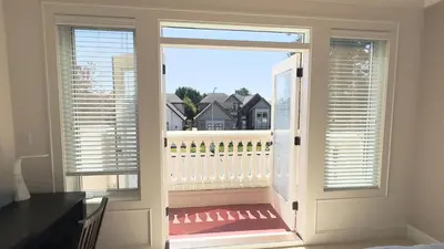 a door to a balcony with a view of a house at #3 Room in Richmond