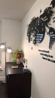 a black clock on a wall with a black table at Carrie The Gentle Nest 1 in Coquitlam