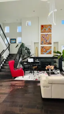 a living room with a piano and a red chair at Carrie The Gentle Nest 1 in Coquitlam
