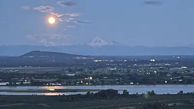 a full moon rising over a city and a river at Carrie The Gentle Nest 1 in Coquitlam