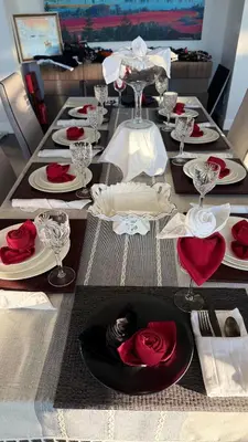 a long table with plates and red roses on it at Carrie The Gentle Nest 1 in Coquitlam