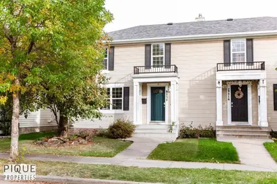 a white house with a blue door and a tree at Nordic Spa Retreat - Hot Tub - King Bed - Firepit - BBQ in Edmonton