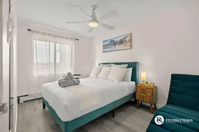 a bedroom with a bed and a blue chair at Downtown 17th Ave Lifestyle with Secure Parking and AC in Calgary