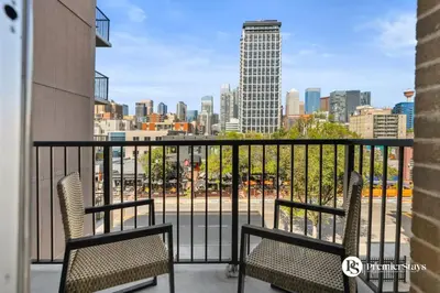 a balcony with two chairs and a view of the city at Downtown 17th Ave Lifestyle with Secure Parking and AC in Calgary