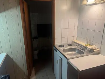 a small kitchen with a sink and a toilet at Big Horn motor Inn in Grande Cache
