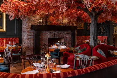 a restaurant with tables and chairs and a fireplace at Rosemead House in Victoria