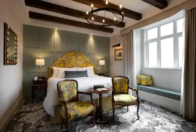 a bedroom with a bed and two chairs and a table at Rosemead House in Victoria