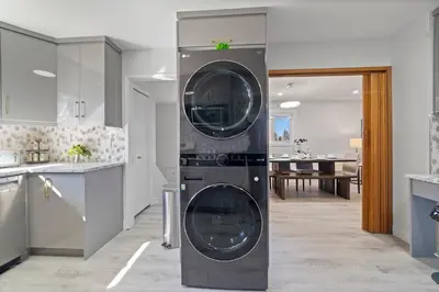 a washer and dryer in the middle of a kitchen at Bungalow Southgate University WEM Rogers Place Saville & Snow Resort in Edmonton