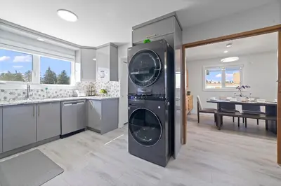 a kitchen with a washer and dryer in a room at Bungalow Southgate University WEM Rogers Place Saville & Snow Resort in Edmonton