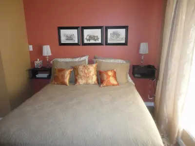a bedroom with a bed with four pillows at Vintage Merlot Bed and Breakfast in Oliver