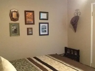 a bedroom with a bed with pictures on the wall at Vintage Merlot Bed and Breakfast in Oliver