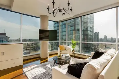 a living room with white furniture and large windows at Summit Mountain & Skyline Views Beltline in Calgary