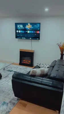 a living room with a black leather couch and a tv at Lucas in Edmonton