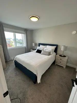 a bedroom with a large bed and a window at Modern One-Bedroom Retreat in Bear Mountain in Langford