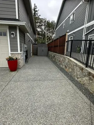 a driveway in front of a house with a fence at Modern One-Bedroom Retreat in Bear Mountain in Langford