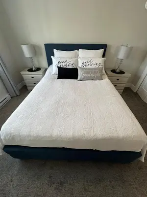 a bedroom with a large white bed with two lamps at Modern One-Bedroom Retreat in Bear Mountain in Langford