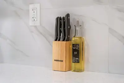 a knife block next to a bottle of wine at Classic 2 Bed-Basement Near the lake in Edmonton