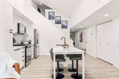 a white kitchen with a sink and a table at 3BR Escape BBQ, Balcony, Near Banff & DT in Canmore