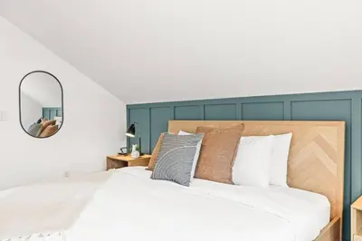 a bedroom with a large bed and a mirror at 3BR Escape BBQ, Balcony, Near Banff & DT in Canmore