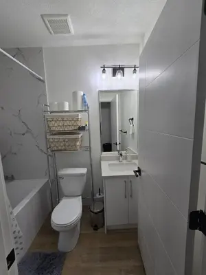 a bathroom with a toilet and a sink and a tub at Lush 1 Bedroom house with WiFi in Edmonton in Edmonton