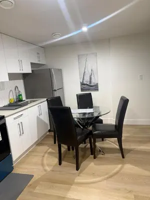 a kitchen with a table with a laptop on it at Lush 1 Bedroom house with WiFi in Edmonton in Edmonton