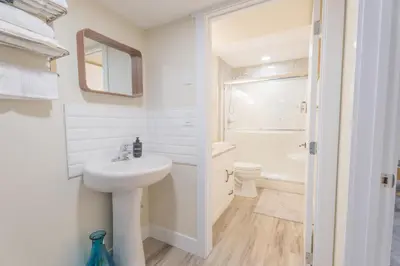 a white bathroom with a sink and a toilet at Anna Suite Rental in Edmonton