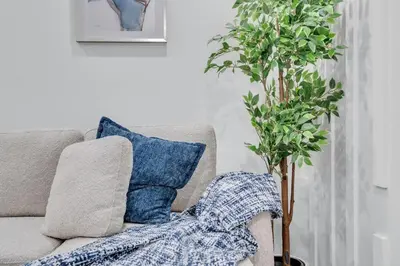 a couch with a pillow and a potted plant at Basement in Calgary - 10 Mins from Calgary Airport in Calgary